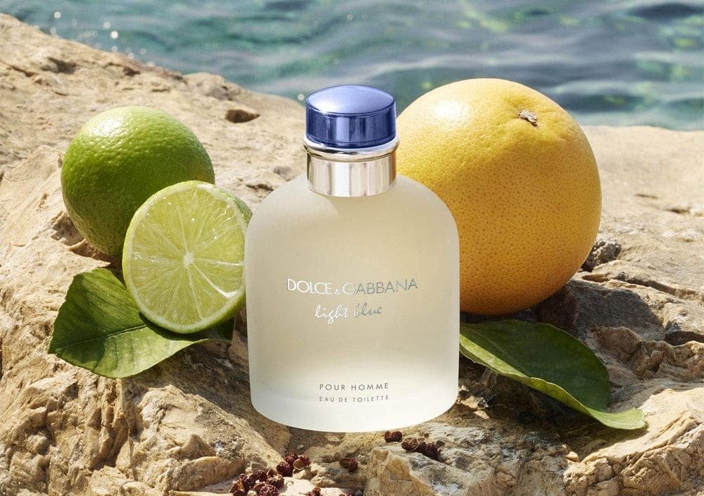 Perfume Light Blue Pour Homme de Dolce & Gabbana sobre un fondo fresco y azul, destacando su diseño limpio y moderno. Perfume masculino con notas cítricas, amaderadas y acuáticas, perfecto para una fragancia veraniega y vibrante